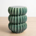 A green ribbed ceramic accent table with a stacked, tiered design.