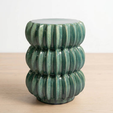 A green ribbed ceramic accent table with a stacked, tiered design.