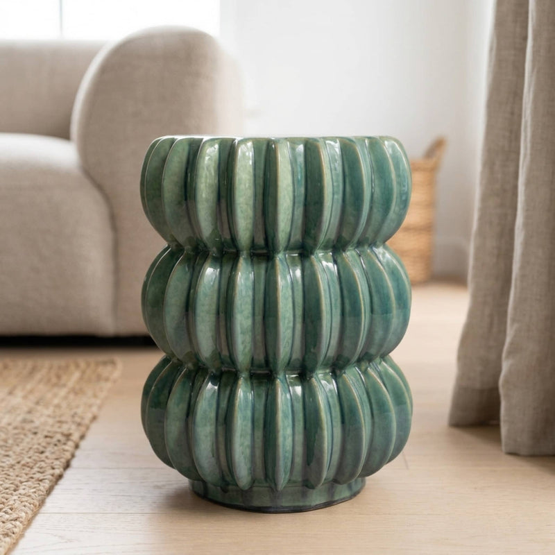 the curvit accent table in a glossy finish, set in a living room with a beige sofa and curtains in the background.