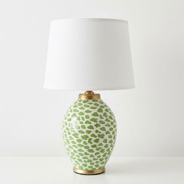 Dapple lime green patterned ceramic table lamp with gold base trim and white drum shade.