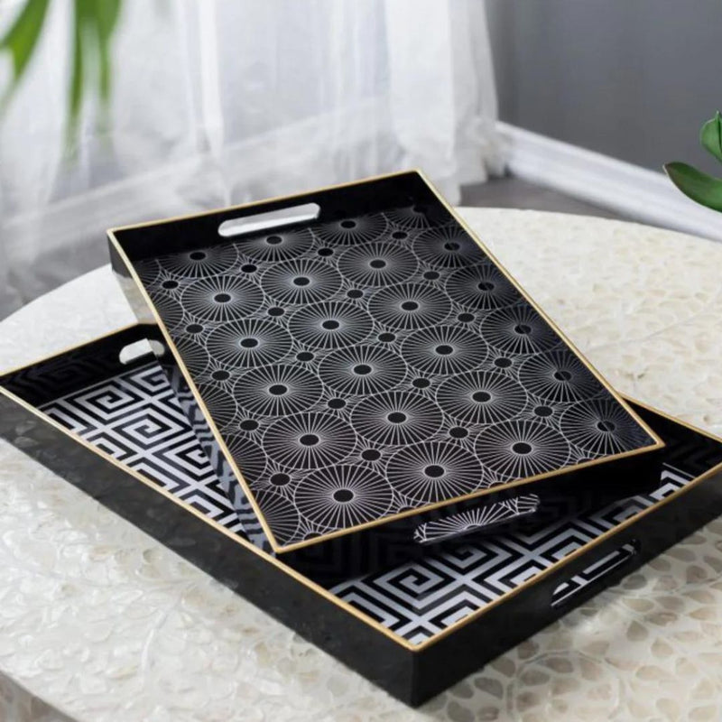 Two black trays with geometric patterns