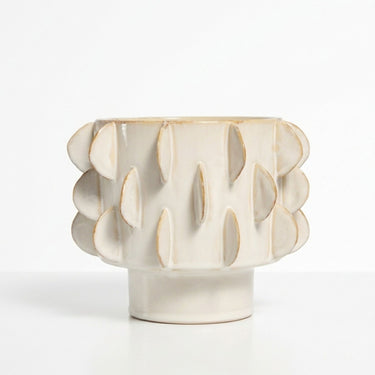 Eclipse sculptural flower plant pot with a textured pattern featuring a pedestal base in a warm ivory cream colour.