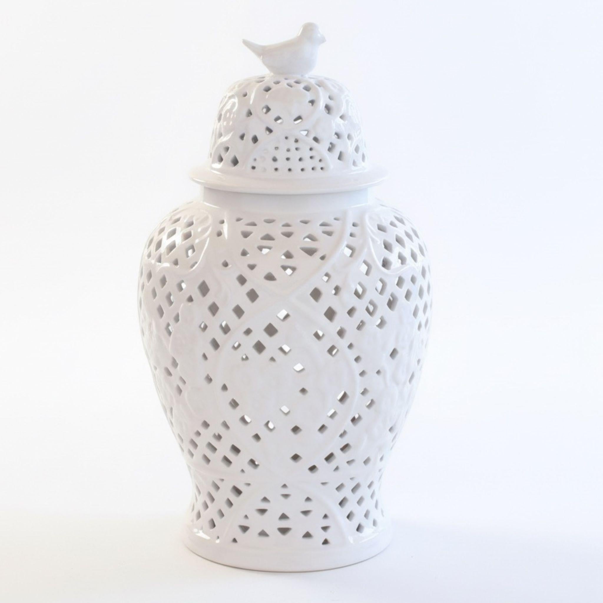 White ceramic jar with decorative lattice design and bird on top 