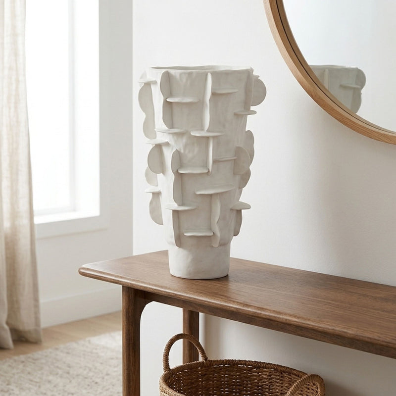 Flange ceramic tall white vase with grid pattern styled in entryway console table.
