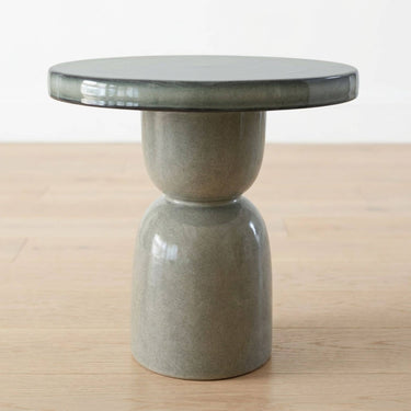 Fleck modern round side table with a glossy dark grey top and pedestal base.