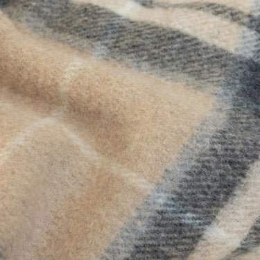 Close-up of throw blanket in tawny Beige traditional Scottish heritage plaid tartan design in camel cream and charcoal grey wool blend.