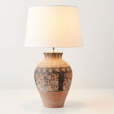 Illuminated Large rustic tribal terracotta statement lamp styled on a table