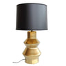 Table lamp with gold base and black shade.