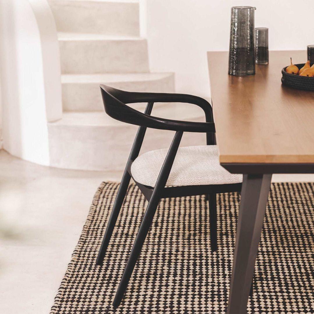 Black dinning chair and wooden table in a modern interior setting