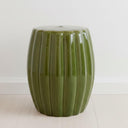 Green ceramic accent table styled in a modern minimalist room.