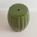 Top view of the green ceramic stool showing the central drainage hole and ribbed design.