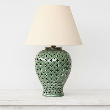 Bold emerald green ginger jar lamp styled as a sophisticated pop of colour in a bright, minimalist interior.