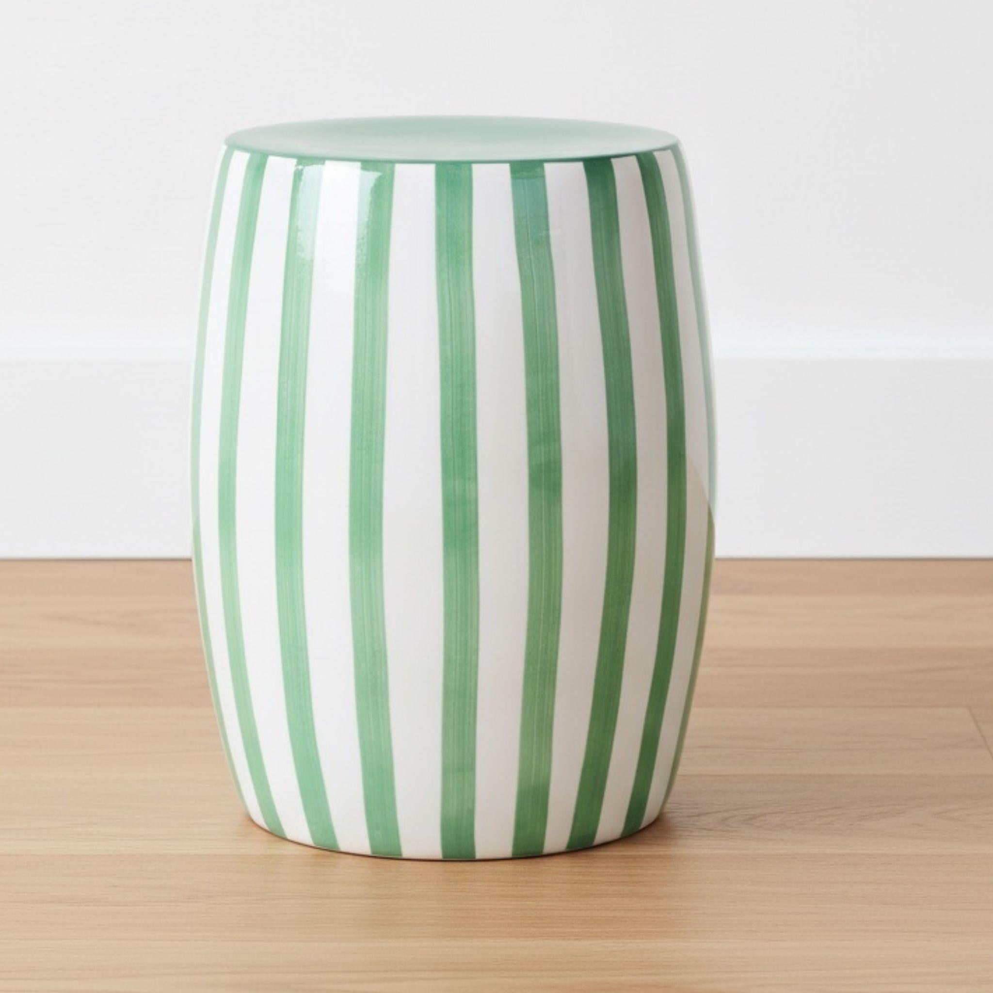 The Green striped side table styled in a minimalist studio setting as a sculptural accent piece for indoor or outdoor patios.