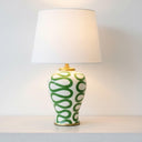 Green Swirl Lamp with elegant gold trim detailing styled as a designer accent on a minimalist white console.