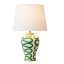 The Green Swirl Lamp featuring a handcrafted white ceramic base with a deep green hand-painted pattern and white fabric shade.