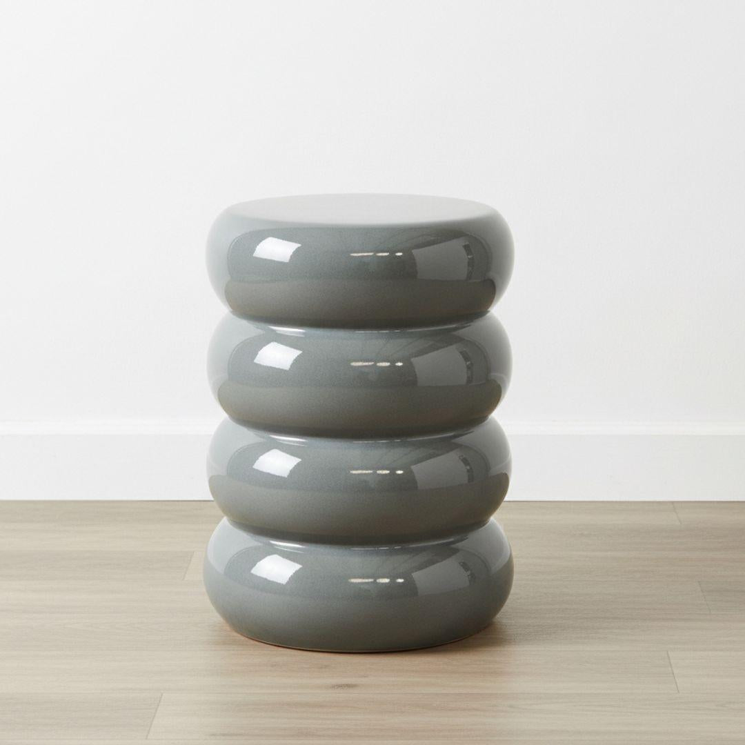 Grey ceramic side table with glossy finish and matte base detail. Sculptural side table for indoor or outdoor styling.