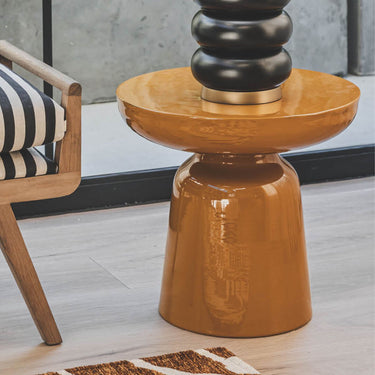 Saffron side tables stands next to a contemporary fabric sofa.