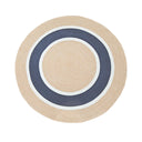 A round rug with concentric circular stripes in natural beige, navy blue, and white.