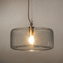 Pendant light with a clear glass shade and a warm glowing bulb inside, suspended by a cord.