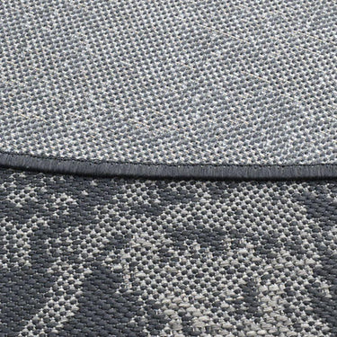 close up of the the UV-resistant large Dichotomized Slate circular rug in dark tones