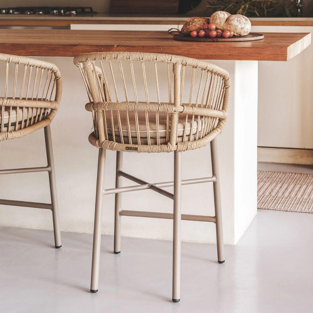 Two outdoor counter chairs in a kitchen setting with a wooden counter.