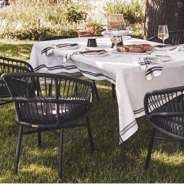 Lola charcoal grey outdoor armchair with easy drain cushion at a patio garden dining table.
