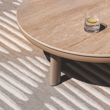 Lookout outdoor rug in a warm clay tone, showing a detailed geometric cross-hatch weave under patio furniture.