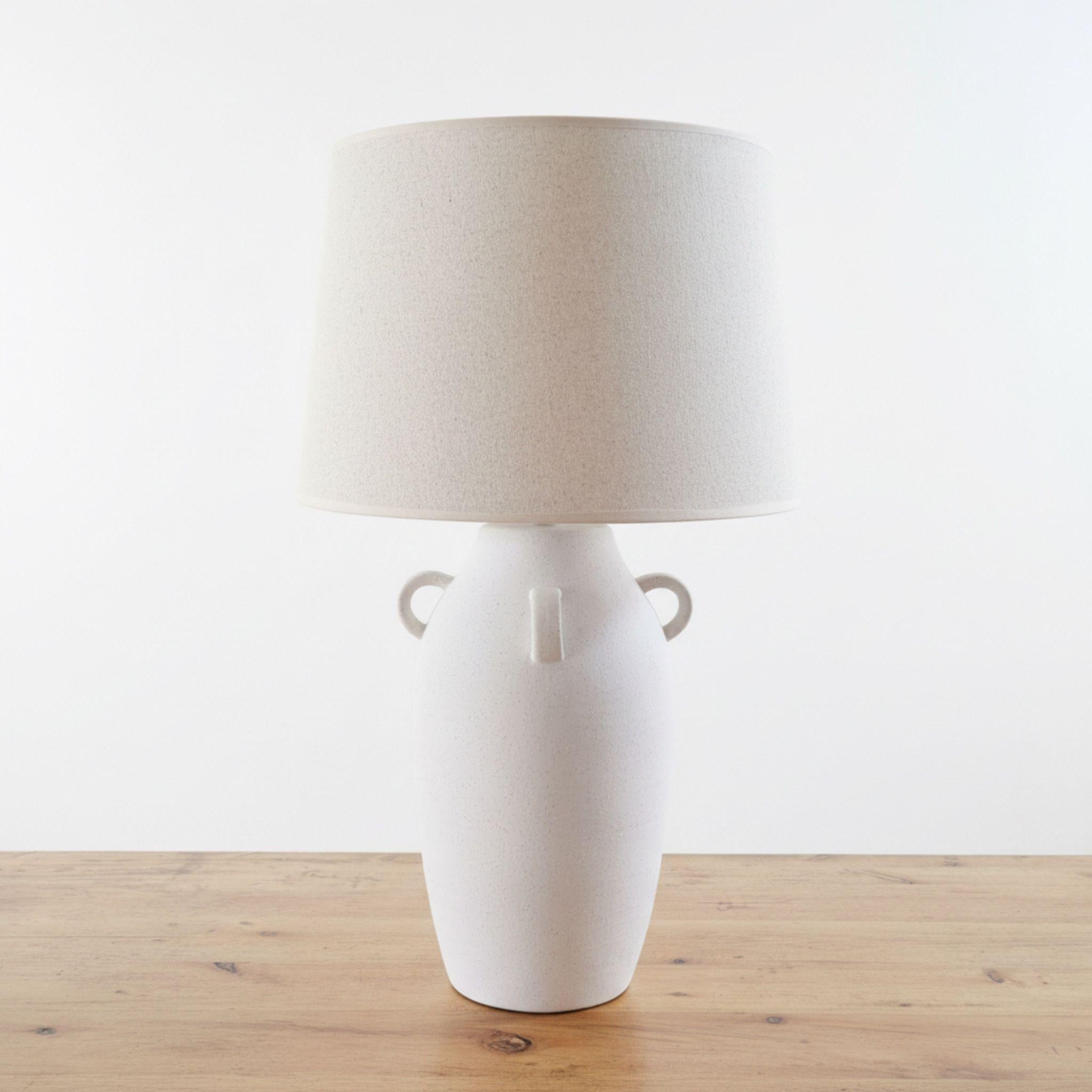 White Ceramic Table Lamp with Loop Handles and shade on a wooden table