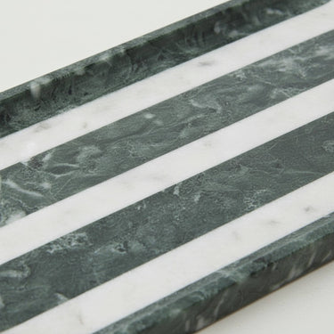 Close-up of marble bathroom tray showing green and white marble veining