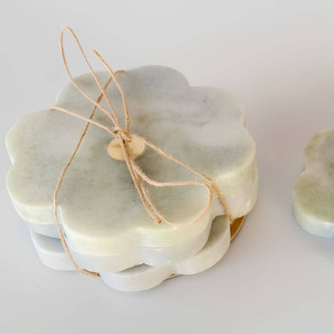 Set of four 11cm grey raw stone coasters with a scalloped flower edge and central brass inlay