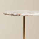 Detail of the marble top side table edge and polished brass stem