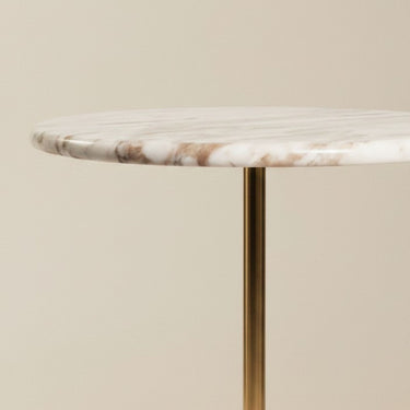 Detail of the marble top side table edge and polished brass stem