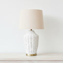 Mira white woven lamp styled on a console table highlighting its crisp organic texture and sophisticated metallic detail stand.