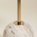 Close-up of brass stem joining the modern marble side table sphere base