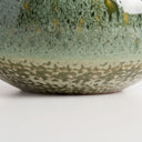 Mottled green ceramic vase with a wide round shape and short flared neck, glazed in layered shades of green