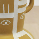 Ochre ceramic stool close-up of eye and line detail