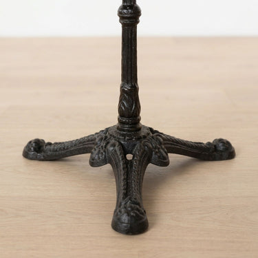 Close-up of an ornate black cast iron table pedestal base.
