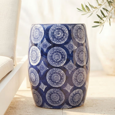 Porto blue and white ceramic stool with intricate medallion pattern styled in a outdoor patio setting.