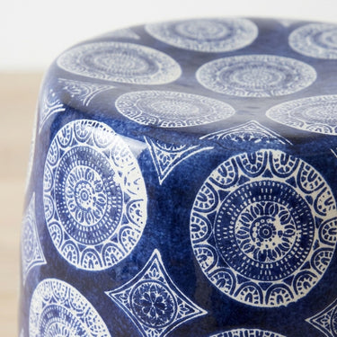 Blue and white ceramic stool  top with intricate medallion pattern.