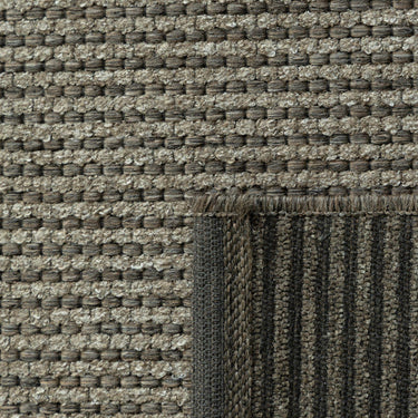 Close-up of the Pridelands outdoor rug showing the green woven texture of recycled PET and polypropylene fibres.