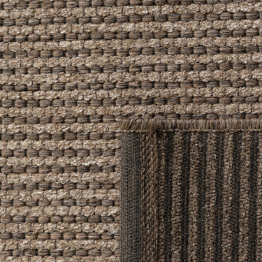 Close-up of the Pridelands outdoor rug showing the dark brown woven texture of recycled PET and polypropylene fibres.