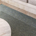  Green Pridelands outdoor rug with a two-toned design and bold border, on a sunlit patio.