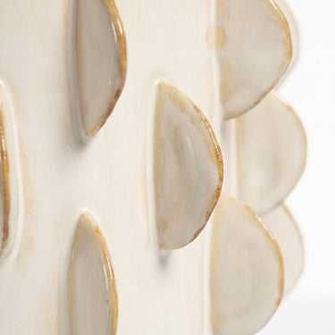 Close-up of the raised tactile rib pattern on the ivory off-white pedestal ceramic pot.