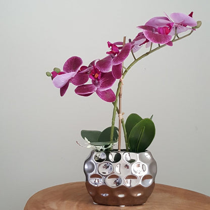 artificial purple orchid in silver pot