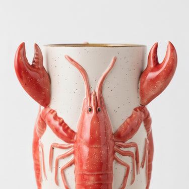 red crayfish ceramic vase showing glossy claws and speckled cream body