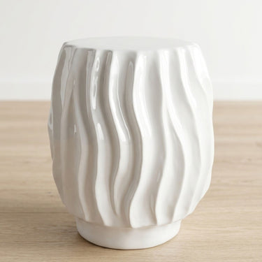 Ripple white ceramic side table with wavy ridged smooth texture.
