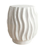 Ripple side table with wavy ridged texture in glossy white ceramic.