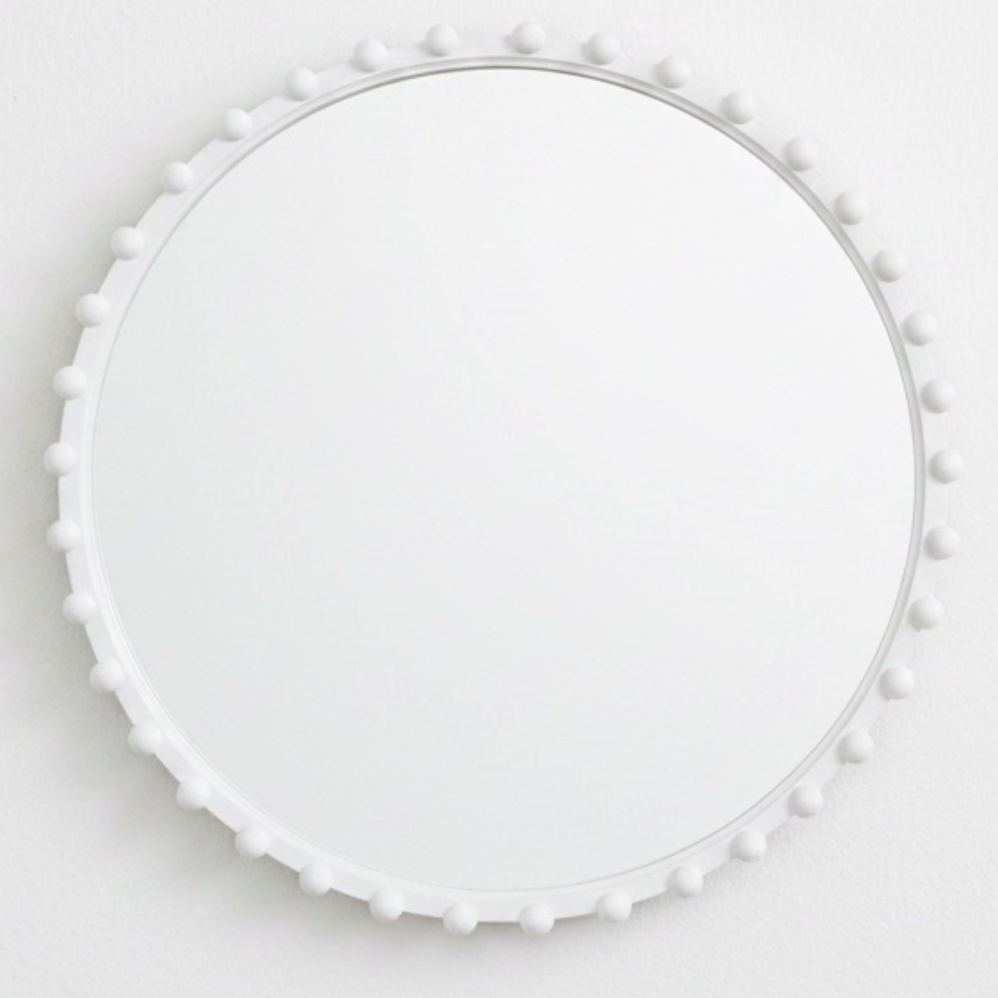 White round mirror with beads styled on wall