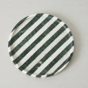 Round marble catchall tray shown from above with green stripes