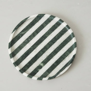 Round marble catchall tray shown from above with green stripes